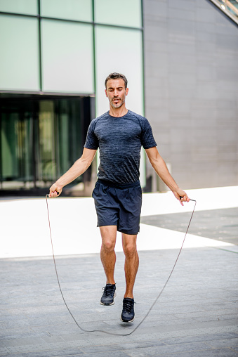 Vertical photo of a man jumping the rope