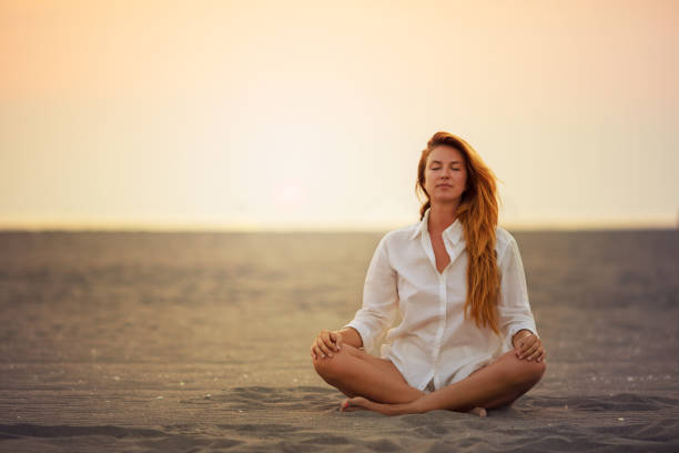 istock Woman doing yoga on the beach at sunset 841887796
