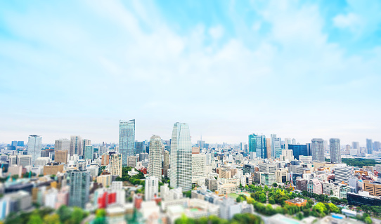 Business and culture concept - panoramic modern city skyline bird eye aerial view from tokyo tower under dramatic sunny and morning blue cloudy sky in Tokyo, Japan. Miniature Tilt-shift effect