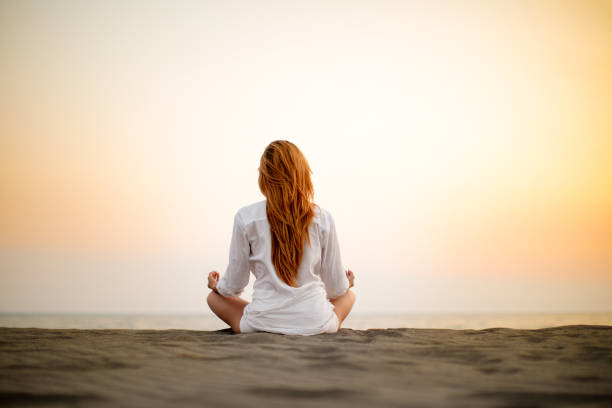 istock Woman doing yoga on the beach at sunset 841890094