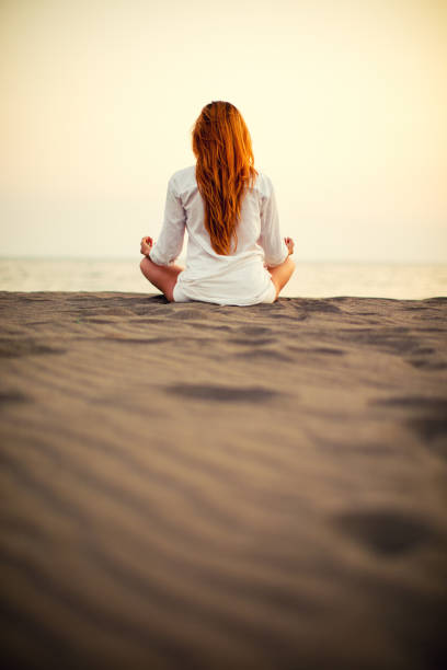 istock Woman doing yoga on the beach at sunset 841890268