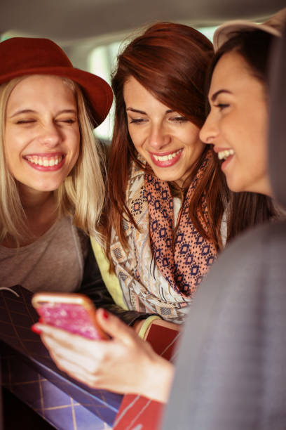 istock Three best friends in the car and reading ridiculous message. 841890754
