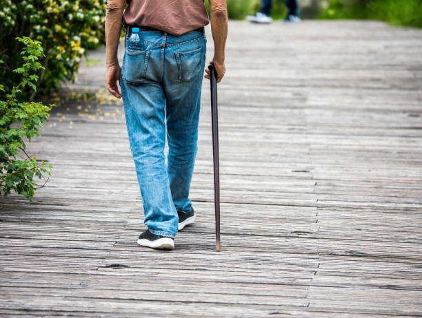 Elderly man with cane on the wood street stock photo