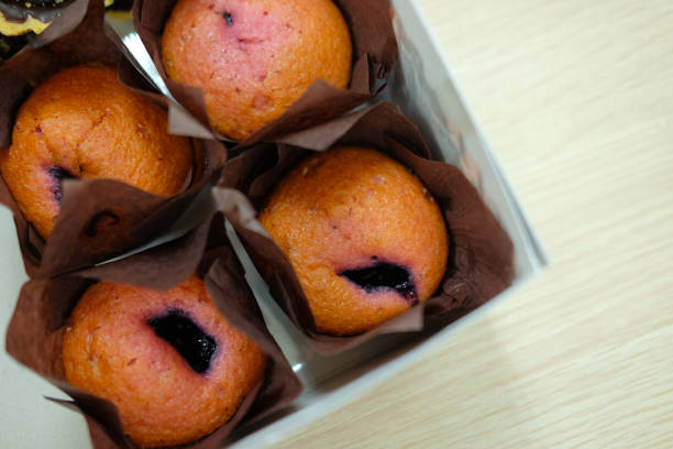 istock Berry muffins in tray on wood table. Top view 841897924