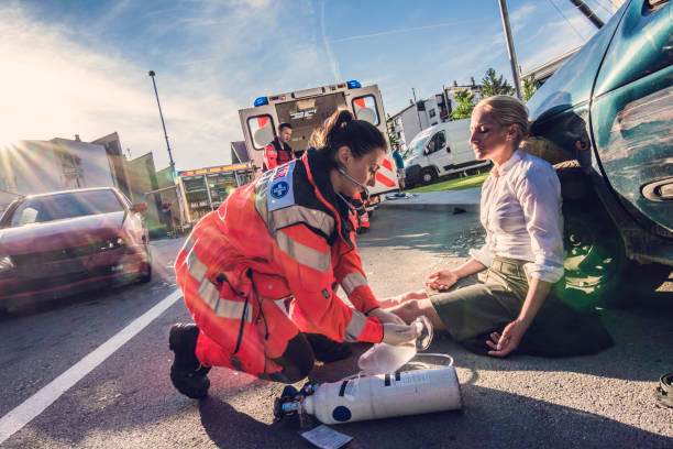 Paramedics are providing first aid. Female doctor life threatening injuries providing first aid to a woman injured in a car accident. Car accident physical damages stock pictures, royalty-free photos & images