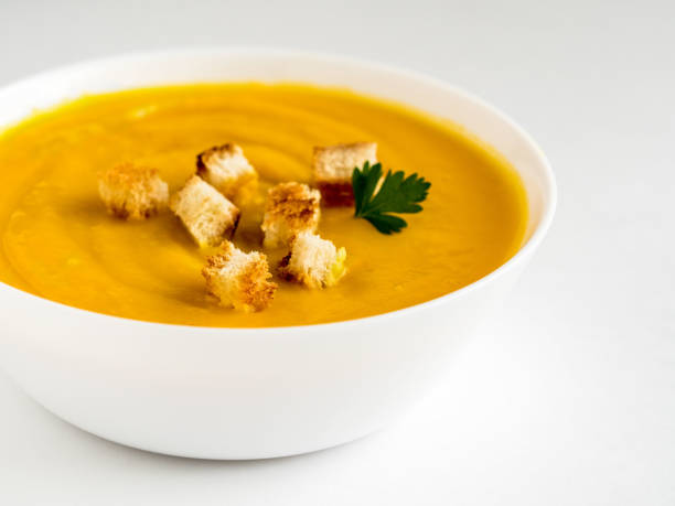 istock pumpkin soup with croutons and herbs in a white Cup on a white background 841902674