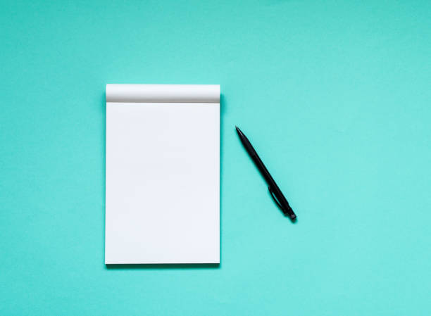 istock Top view workspace mockup on aqua background with open notebook and pen 841902768
