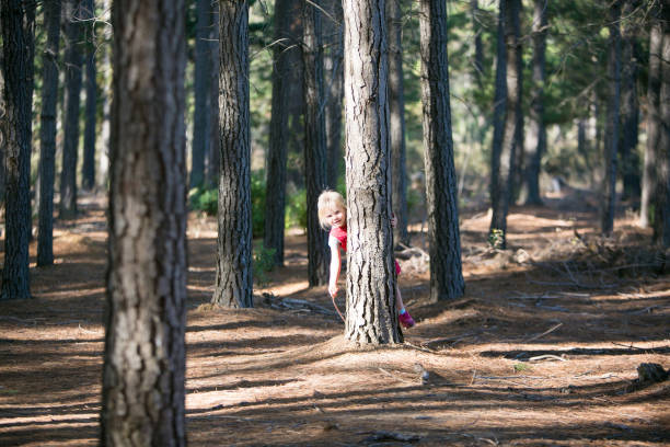 istock A young blond girl hides amongst the trees 841905388