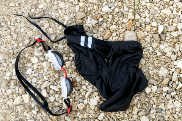 istock Swimming goggles and swim briefs on pebble beach from above. 841909732