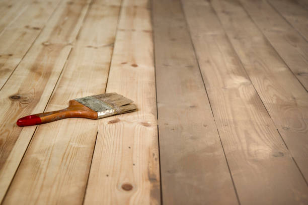 malowana drewniana podłoga i szczotka na nim. - wood stain paint deck paintbrush zdjęcia i obrazy z banku zdjęć