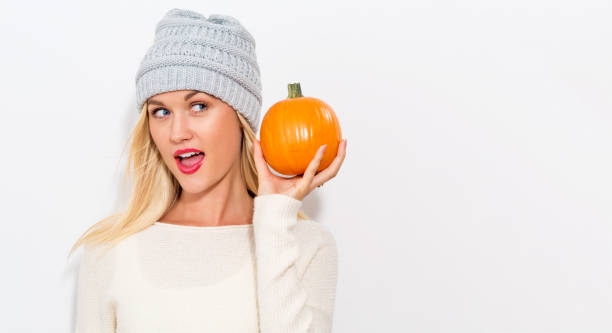 istock Young woman holding a pumpkin 841923638