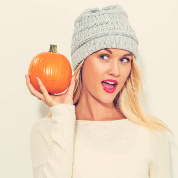 istock Young woman holding a pumpkin 841923666