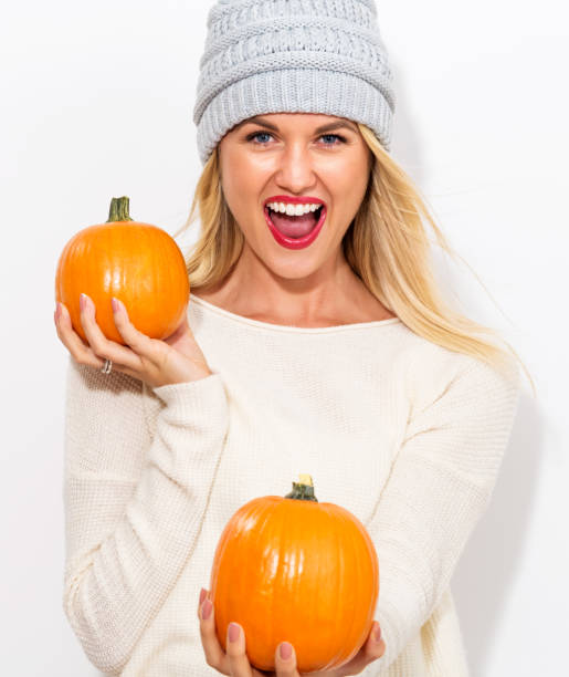 istock Young woman holding pumpkins 841923670