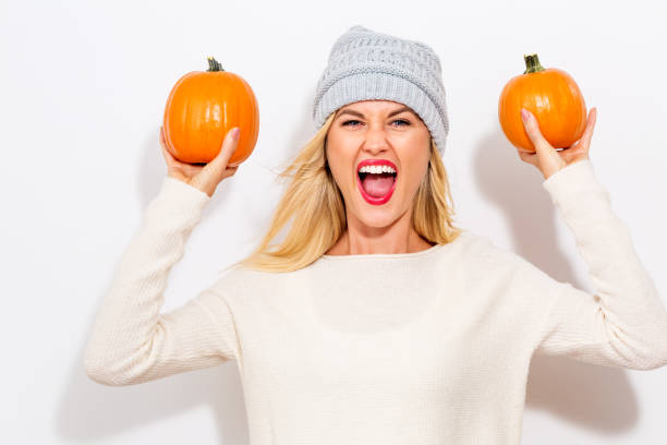 istock Young woman holding pumpkins 841923676