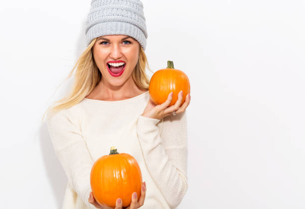 istock Young woman holding pumpkins 841923686