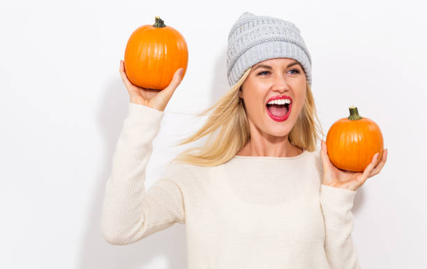 istock Young woman holding pumpkins 841923690