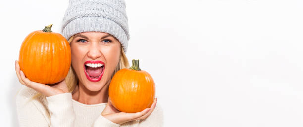 istock Young woman holding pumpkins 841923718