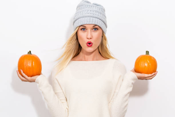 Young woman holding pumpkins stock photo