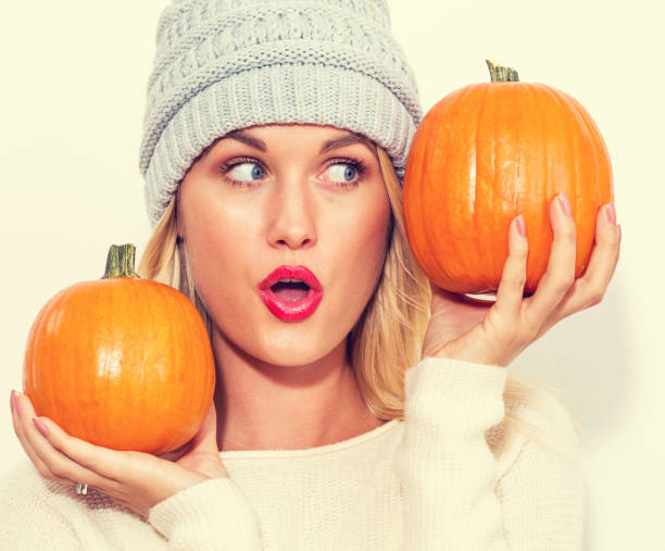 istock Young woman holding pumpkins 841923740