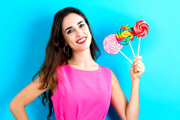 istock Young woman holding lollipops 841924442