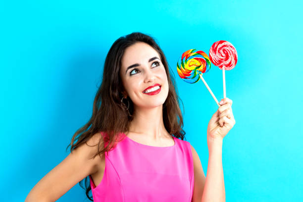 istock Young woman holding lollipops 841924464