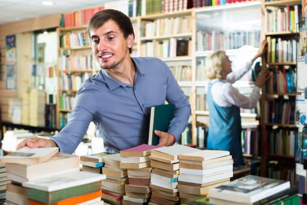 istock young man among bookshelves 841930580