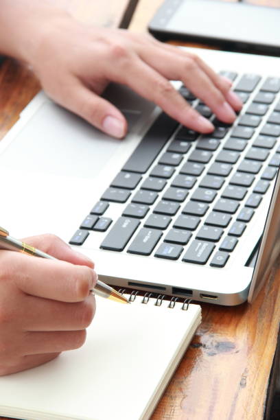 istock Female hand writing with laptop 841930668