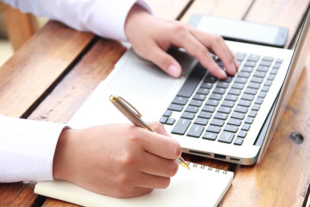 istock Female hand writing with laptop 841934502