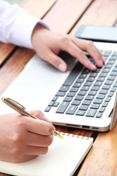istock Female hand writing with laptop 841934694