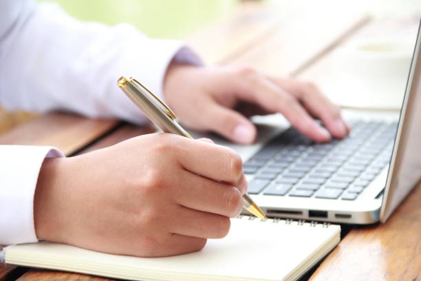 istock Female hand writing with laptop 841934944