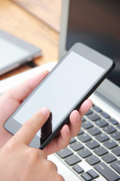 istock Woman using mobile phone with laptop outdoors 841935082