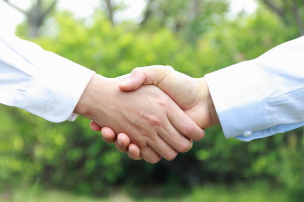 istock Man and woman hand shaking on nature background 841935370