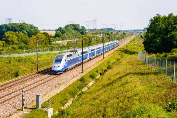 A TGV high speed train driving in the french countryside. Moisenay, France - August 23, 2017: A double-decker TGV Duplex high speed train in Atlantic livery from french company SNCF driving on the Southeast TGV line along the A5 highway in the countryside. duplex photos stock pictures, royalty-free photos & images