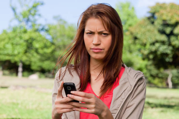 istock Woman with a stern expression on her face while holding a phone 841937998