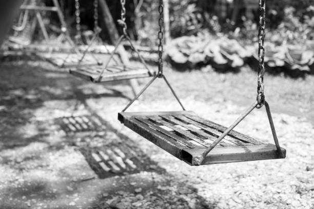 пустые качели на детской площадке. пустые качели цепи в летний детский детский игровой площадке. - swing playground empty abandoned стоковые фото и изображения