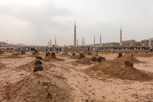 Ancient graves in Jannat Al Baqi Cemetery in Medina Ancient graves in Jannat Al Baqi Cemetery and the Prophet's Mosque al Masjid an Nabawi at the background in Medina, Saudi Arabia al masjid an nabawi stock pictures, royalty-free photos & images