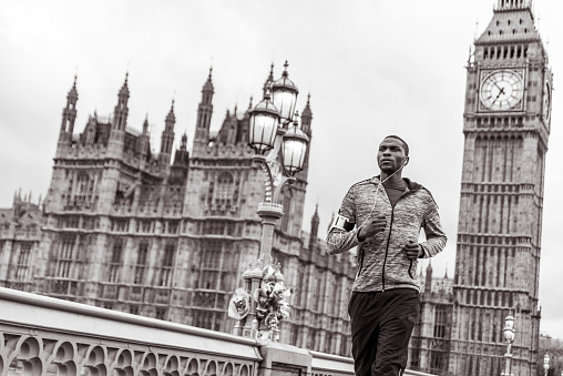 Young black man jogging over the Westminster bridge