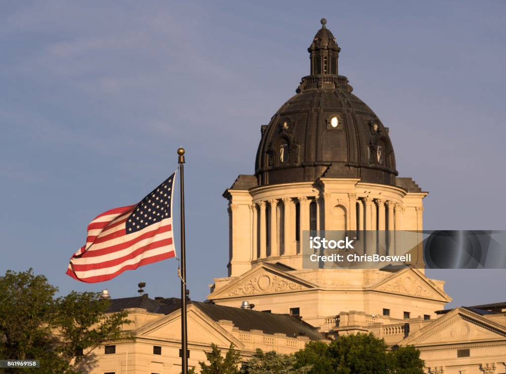 South Dakota State Capital Building Hughes County Pierre SD The American Flag waves in front of the capitol dome in Pierre, SD South Dakota State Capitol Stock Photo