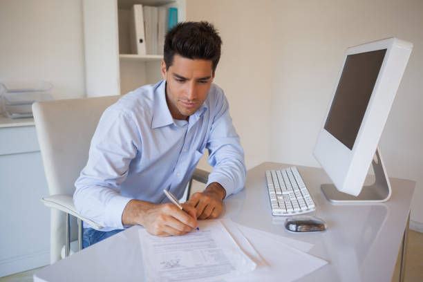 istock Casual businessman sitting at desk writing 841970956
