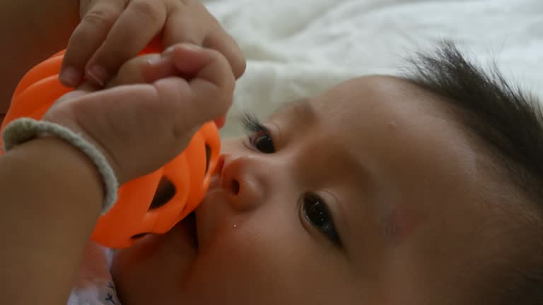 Asian baby smiling with pumpkin toy