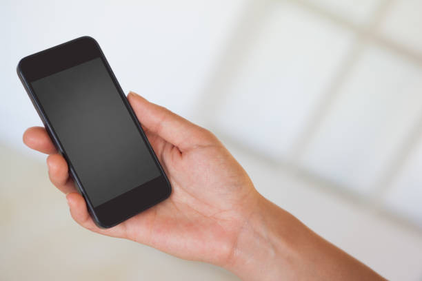 istock Womans hand holding black smartphone 841985918