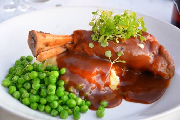 pernil de cordeiro com ervilhas verdes. - lamb chop shank cooked - fotografias e filmes do acervo