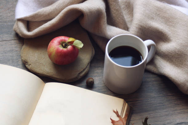 fall still life with apples, open book and leaves over rustic wooden background - macintosh apple imagens e fotografias de stock