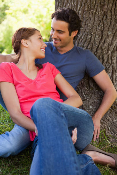 istock Two friends looking at each other while they sit together in the shade 841991856