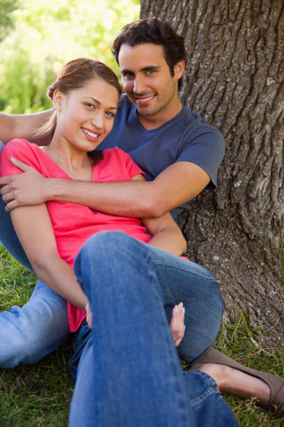 istock Man looking ahead as he holds her while they sit together in the shade 841991872