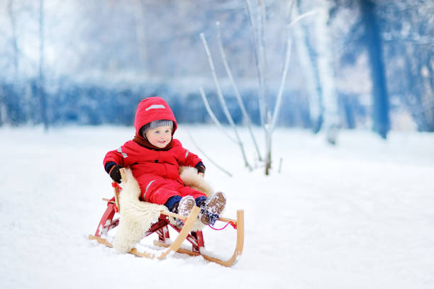 little boy in red winter clothes with toboggan - 4721 imagens e fotografias de stock