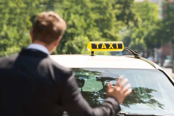 Close-up Photo Of A Businessman Calling Taxi