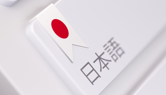 High quality 3d render of a modern keyboard with dictionary text  in Japanese and  a Japanese flag. Dictionary keyboard button has a Japanese flag icon on it and it is in focus. Horizontal composition with copy space.