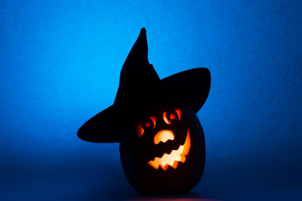 istock Happy Halloween pumpkin with a candlestick, funny face face on a blue background 842031846
