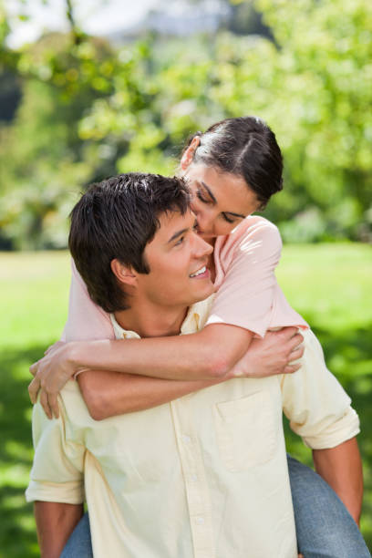 istock Man looking at his friend as he is carrying her on his back 842036932